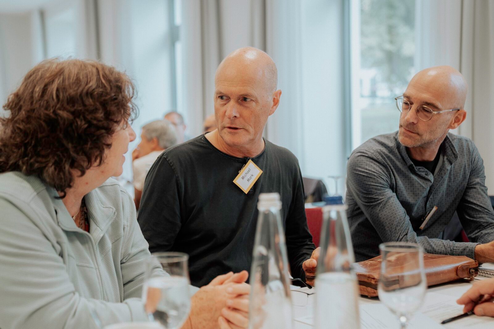 Teilnehmer im Gespräch am Tisch